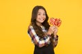 She has sweet tooth. Little girl enjoy delicious taste of lollipops. Happy small child hold candies with sweet taste on