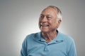 This has turned out to be quite the fun day. an older man looking off into the distance in a studio against a grey Royalty Free Stock Photo