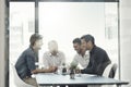 Hashing out ideas in the boardroom. a group of businessmen having a meeting around a table in an office.