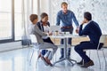 Hashing out new ideas with the team. a team of businesspeople working on a laptop together at a table in the office. Royalty Free Stock Photo