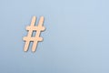 Hashtag sign made of wooden material on blue background Royalty Free Stock Photo