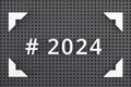 Hashtag 2024 written with white numbers in a frame on gray pegboard