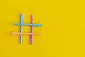 Hashtags sign made of colored penls on yellow background