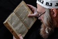 A Hasidic Jew reads Siddur. Religious orthodox Jew with a red beard and with pace in a white bale Royalty Free Stock Photo