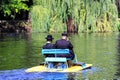 2 Hasidic Jews in black clothes ride a catamaran in the Park in Uman, Ukraine, Jewish New Year, Orthodox Religious Jew