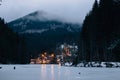 Winter Hasmas Mountains, Eastern Carpathians, Romania. Foggy Morning, lights of village