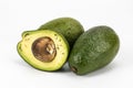 Fresh two Avocados and cut piece composition with wooden roots Royalty Free Stock Photo