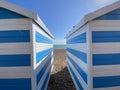 Hastings, East Sussex, UK -03.15.2022: Hastings seafront beach huts on summer day beautiful blue white striped huts on pebble beac Royalty Free Stock Photo