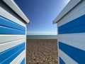 Hastings, East Sussex, UK -03.15.2022: Hastings seafront beach huts on summer day beautiful blue white striped huts on pebble beac Royalty Free Stock Photo