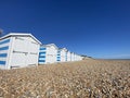 Hastings, East Sussex, UK -03.15.2022: Hastings seafront beach huts on summer day beautiful blue white striped huts on pebble beac Royalty Free Stock Photo