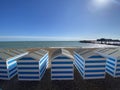 Hastings, East Sussex, UK -03.15.2022: Hastings seafront beach huts on summer day beautiful blue white striped huts on pebble beac Royalty Free Stock Photo