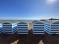 Hastings, East Sussex, UK -03.15.2022: Hastings seafront beach huts on summer day beautiful blue white striped huts on pebble beac Royalty Free Stock Photo