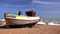 HASTINGS, UK - JUNE 15, 2013: A beach launched fishing boat with strong waves in the background