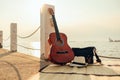 Hat, Bag and Guitar on reed mat near the sea at sunset. Travel, vocation, holiday, summer concept Royalty Free Stock Photo