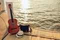 Hat, Bag and Guitar on reed mat near the sea at sunset. Travel, vocation, holiday, summer concept Royalty Free Stock Photo