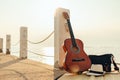 Hat, Bag and Guitar on reed mat near the sea at sunset. Travel, vocation, holiday, summer concept Royalty Free Stock Photo