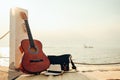 Hat, Bag and Guitar on reed mat near the sea at sunset. Travel, vocation, holiday, summer concept Royalty Free Stock Photo