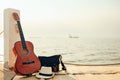 Hat, Bag and Guitar on reed mat near the sea at sunset. Travel, vocation, holiday, summer concept Royalty Free Stock Photo