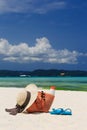 Hat, bag, sun glasses and flip flops on tropical beach Royalty Free Stock Photo