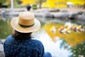 hat by campus pond, ducks nearby, student watching Royalty Free Stock Photo