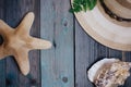 a hat, a fern leaf, a starfish, sea shells on the wooden table Royalty Free Stock Photo