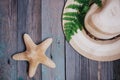 a hat, a fern leaf, a starfish, sea shells on the wooden table Royalty Free Stock Photo