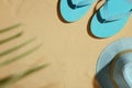 Hat and flip flops on beach sand, top view Royalty Free Stock Photo