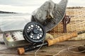 Hat and fly fishing gear on table near the water Royalty Free Stock Photo