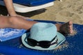 Hat and glasses on the beach background. A man is lying on a sun lounger. Royalty Free Stock Photo