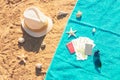 Hat, money, passport, credit card and sunglasses on towel on sand beach. Top view