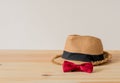 Hat and red bowtie are placed on wooden floor. Royalty Free Stock Photo