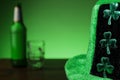 Hat with shamrock in focus. Beer bottle and glass out of focus in the background. Saint Patrick theme background. Copy space