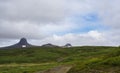 Hat shape mountains with snow capes, green hills and grass meadow, blue sky white clouds, Iceland summer landscape Royalty Free Stock Photo