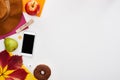 Hat, smartphone, donut, pear, apple, earphones, dry leaf, wooden block with october inscription, green and yellow paper