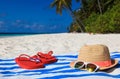 Hat, sun glasses and flip flops on a tropical beach