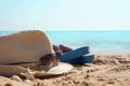 Hat with sunglasses and beach slippers on the sand against the blue sea Royalty Free Stock Photo