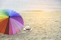 Hat, sunglasses and rainbow colored umbrella on a tropical beach Royalty Free Stock Photo