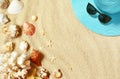 Hat and sunglasses on the sandy beach with seashells. Summer background Royalty Free Stock Photo