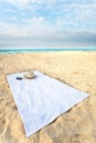 Hat and Sunglasses on a towel on the beach with dr Royalty Free Stock Photo