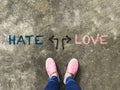 Hate or Love arrow and pink slipper shoe on concrete background