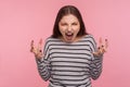 Hate this! Portrait of crazy aggressive woman in striped sweatshirt roaring wild and raising hands in anger