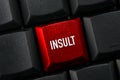 A Black keyboard with a red key and the insult word
