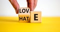 From hate to love symbol. Hand turns the cube and changes the word 'hate' to 'love'.
