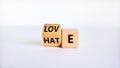 From hate to love symbol. Turned the wooden cube and changed the word `hate` to `love`. Beautiful white table, white backgroun