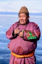 Hatgal, Mongolia, Febrary 23, 2018: mongolian man dresses in traditional clothing on a frozen lake Khuvsgul and holds