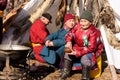 Hatgal, Mongolia, Febrary 25, 2018: older Mongolian lady and two men are sitting next to a stove near the yurt