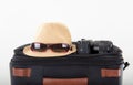 Hats and micro single cameras on luggage compartment and box in front of white background