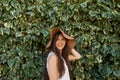 Hats are part of my style. Cropped portrait of a pretty teenage girl standing in front of a large hedge. Royalty Free Stock Photo