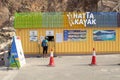 Hatta lake between Hajar Mountains with many kayaks and boats for rent. Man is buying tickets in Hatta Kayak office.
