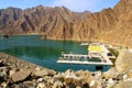 Beautiful deep green Hatta lake between Hajar Mountains with many kayaks and boats for rent. Overview of Hatta dam in UAE.